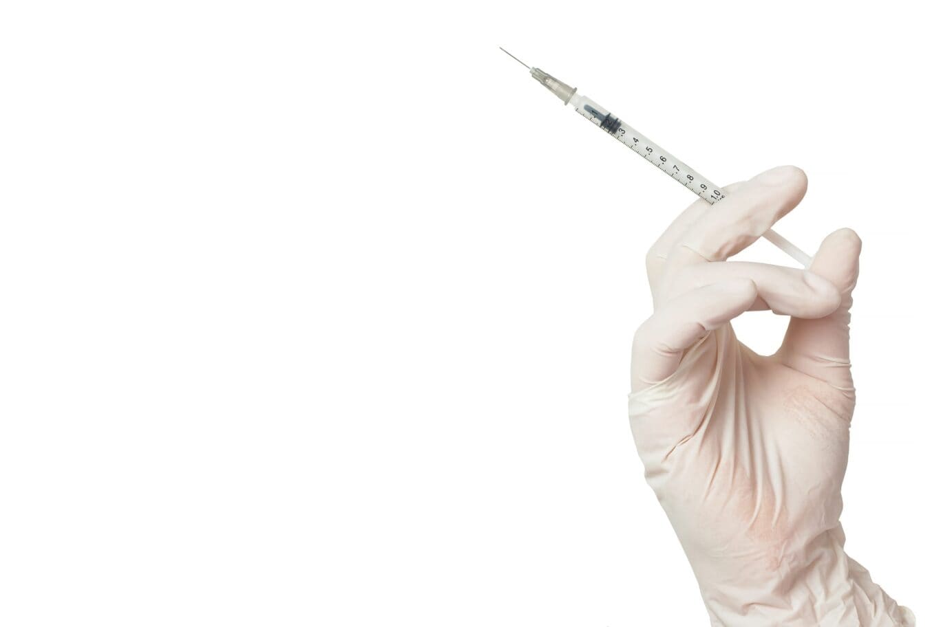 Medical professionals hand holding a syringe