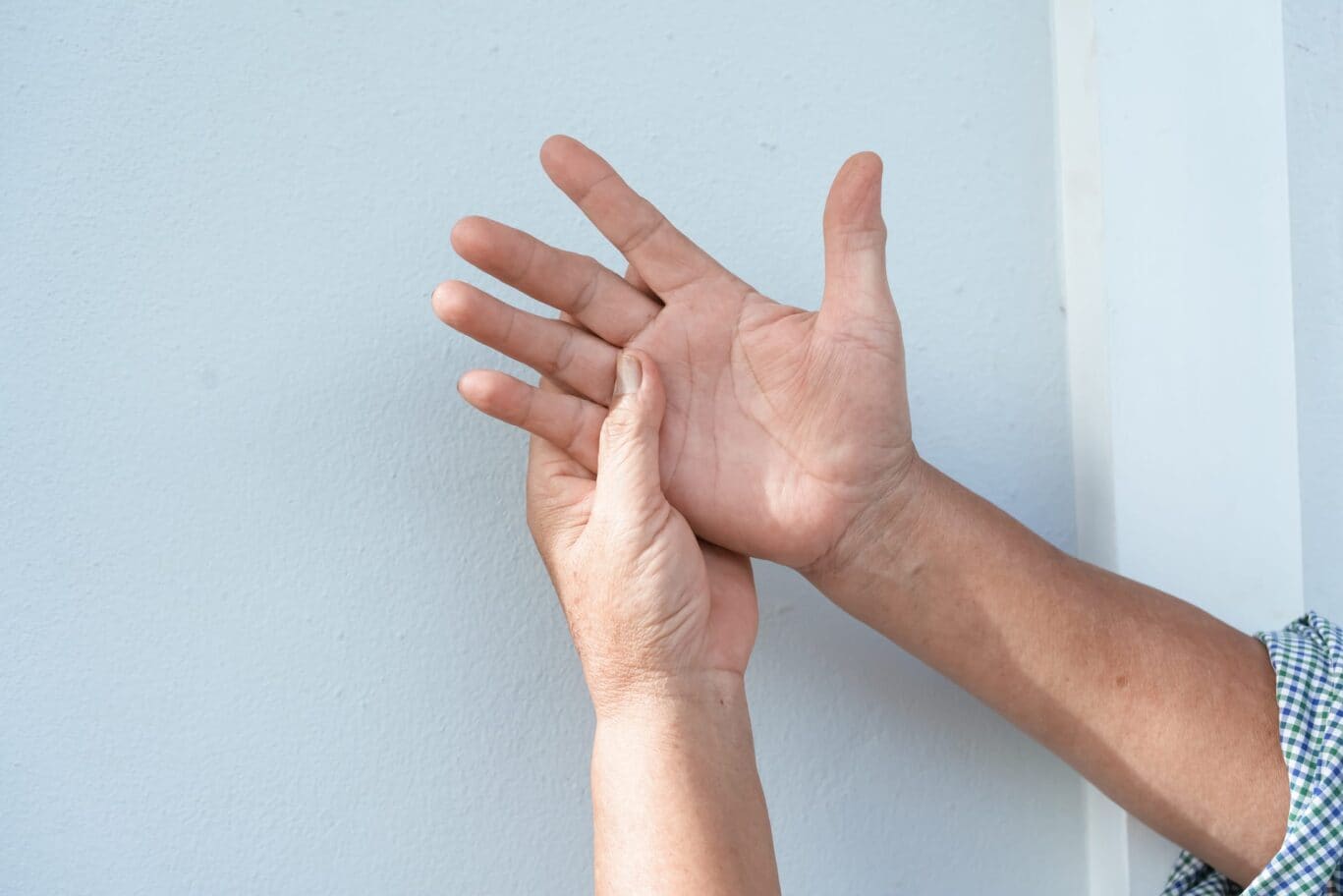 A hand holding another hand suffering from carpal tunnel syndrome